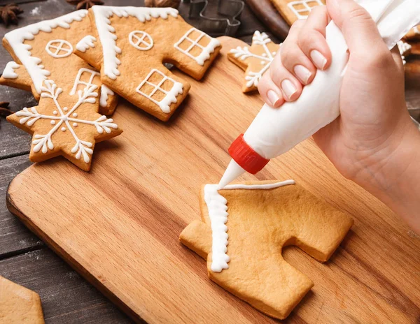 Vrouw versieren zelfgemaakte peperkoek cookies, bovenaanzicht — Stockfoto