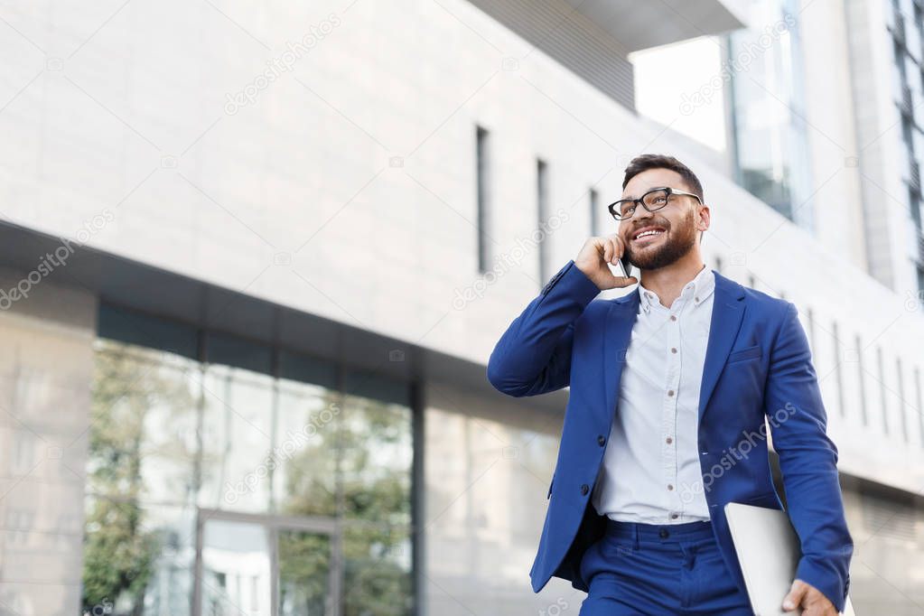 Bearded businessman talking on cell phone with customer