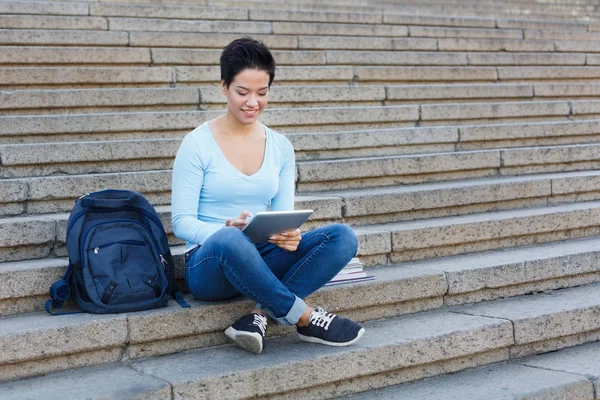 Leende kvinna student arbetar med platta utomhus — Stockfoto