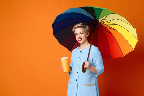 Heureuse femme souriante avec parapluie multicolore, espace de copie — Photo