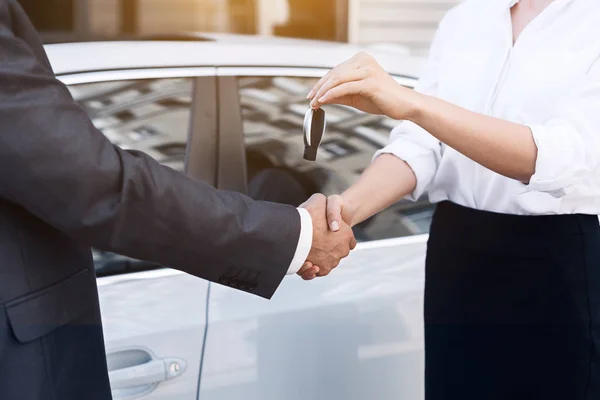 Vendedora de coches dando la llave al nuevo propietario — Foto de Stock