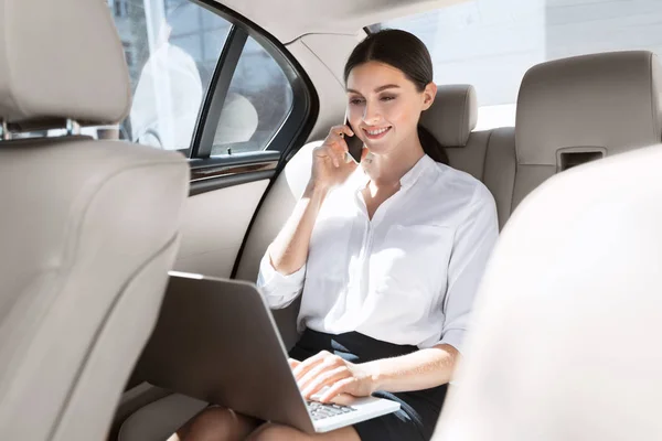 Kvinnliga företagare sitter i bilen med laptop — Stockfoto