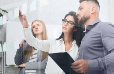 Planları tartışıyor. Yapışkan notlar yapışmasını iş adamları