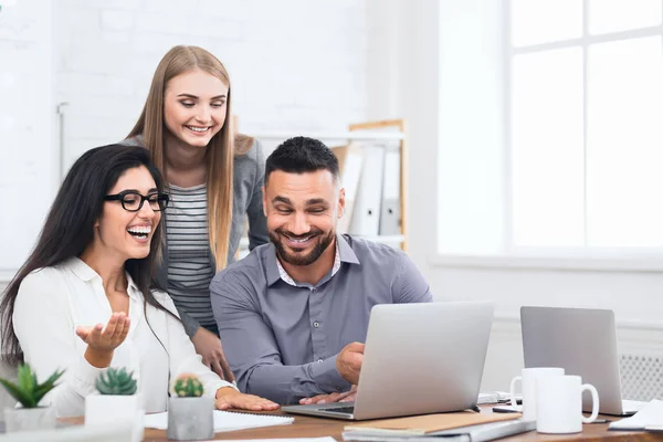 Tre glada anställda som får goda nyheter på laptop — Stockfoto