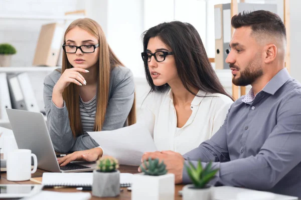 Equipo de negocios concentrado con laptop y documentos — Foto de Stock