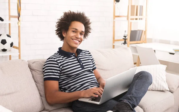 Afro-americano chico viendo videos divertidos en el ordenador portátil en casa —  Fotos de Stock