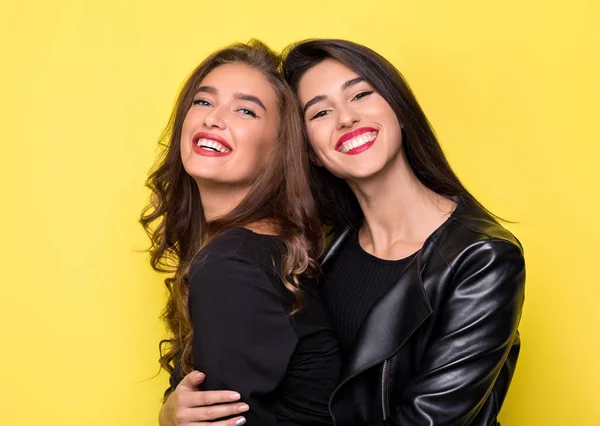 Deux belles filles étreignant sur fond jaune — Photo