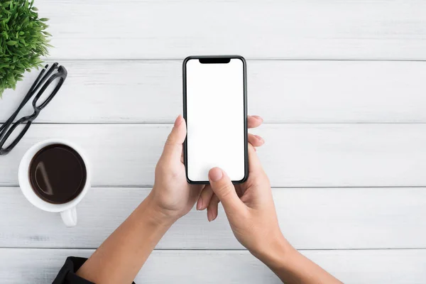 Χέρι χρησιμοποιώντας smartphone σε άσπρο φόντο ξύλινη — Φωτογραφία Αρχείου