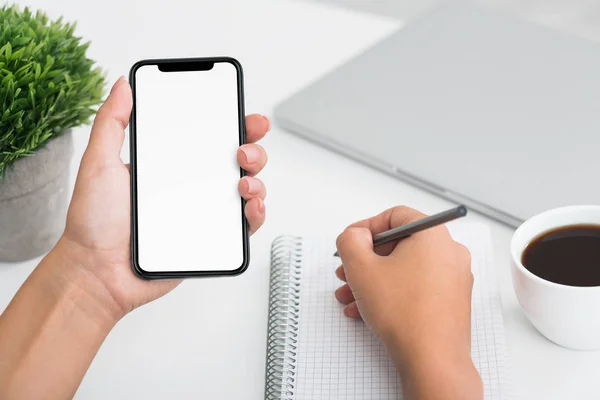 Schüler schreiben auf Notizbuch und Smartphone — Stockfoto