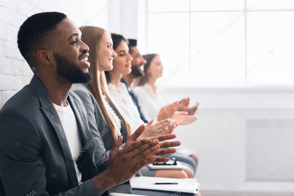 Multiethnic business group greeting speaker with clapping