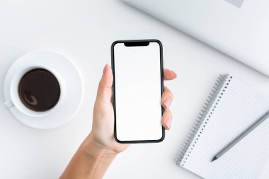 Boş ekran ile akıllı telefon workpspace üzerinde tutan el
