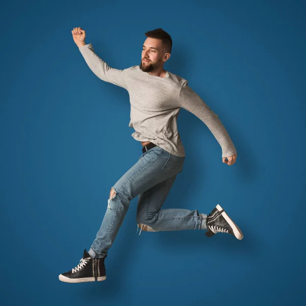 Bonito homem pulando no estúdio — Fotografia de Stock