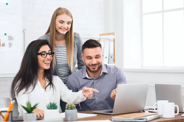 Drei junge Geschäftsleute schauen auf Laptop — Stockfoto