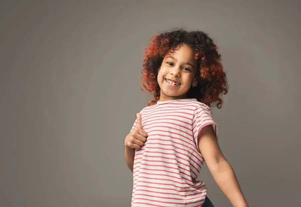 Entzückende afrikanische kleines Mädchen mag es vor grauem Hintergrund — Stockfoto