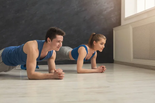 Treinamento de prancha de casal fitness dentro de casa — Fotografia de Stock
