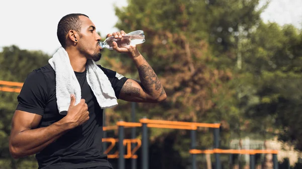 Deportivo hombre beber agua después del entrenamiento al aire libre —  Fotos de Stock