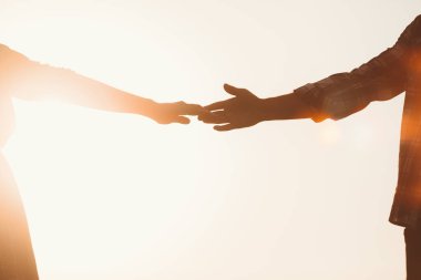 Siluet aşıkların birbirlerine doğru uzanan eller