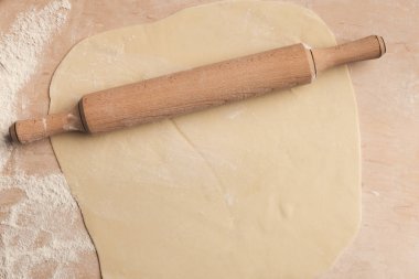 Hamur merdane ile ahşap arka planda, üstten görünüm rulo