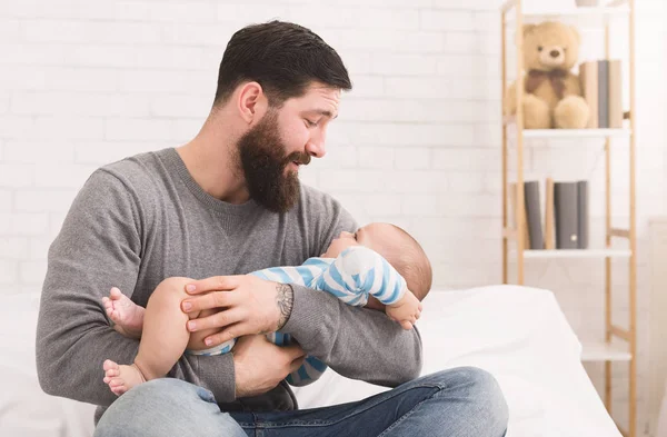 Jovem pai segurando chorando sonolento bebê recém-nascido bonito — Fotografia de Stock