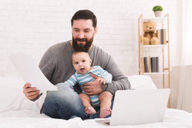 Belgeleri okuma ve bebekle oturan işadamı