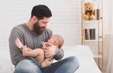 Baba tutarak ve onun kollarında ağlayan bebek yatıştırıcı