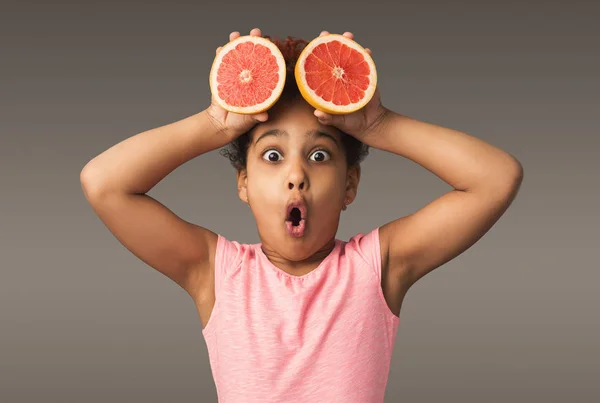 Маленька афроамериканська дівчинка грає зі свіжими цитрусовими фруктами — стокове фото