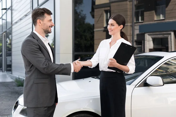 Cliente masculino que compra o veículo na concessionária do carro — Fotografia de Stock