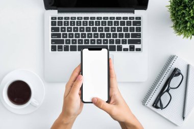 Beyaz ahşap arka plan üzerinde Smartphone kullanarak ele