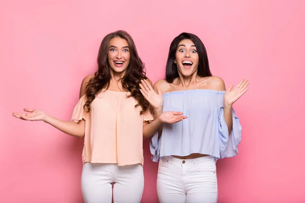 Emocionadas amigas de pie sobre fondo rosa — Foto de Stock