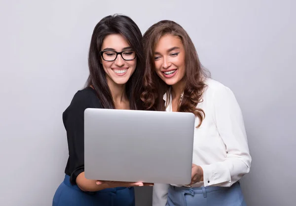 Due amiche che navigano su internet insieme su un computer portatile — Foto Stock