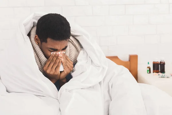 Homem doente soprando o nariz na cama em casa — Fotografia de Stock