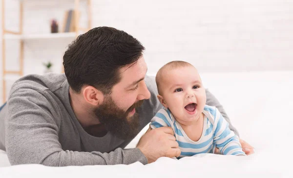 Pai feliz brincando com bebê adorável no quarto — Fotografia de Stock