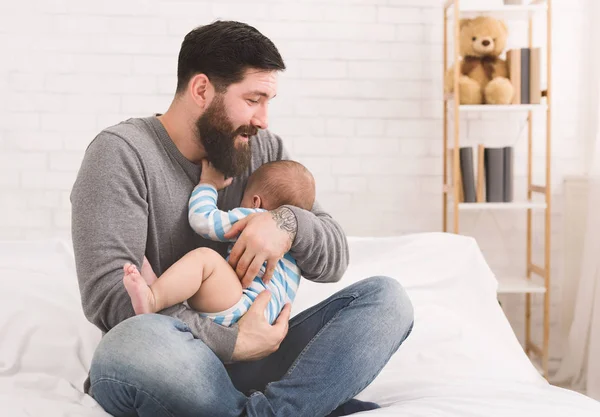 Bebé recién nacido llorando en las manos del padre en la cama —  Fotos de Stock