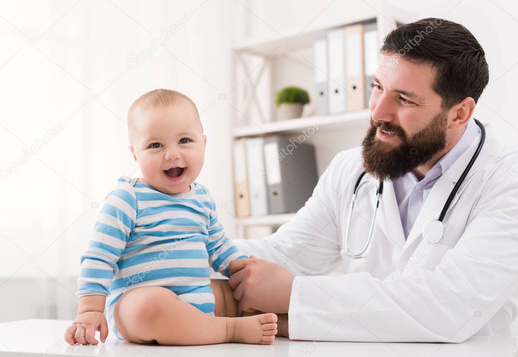 Adorable baby sitting with doctor at clinic