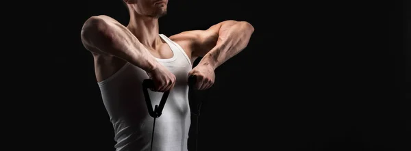 Lekkoatletycznego mięśni mężczyzna wykonujących w sposób elastyczny expander w black — Zdjęcie stockowe