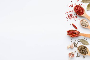 Beyaz zemin üzerine kaşık içinde çeşitli karabiber