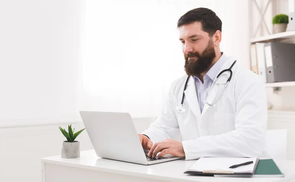 Médico trabajando con computadora portátil en la oficina — Foto de Stock