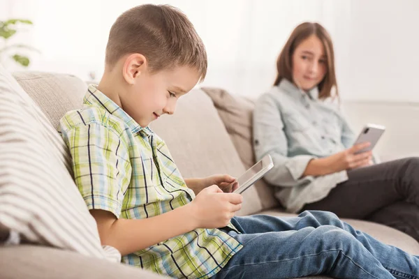 Liten pojke som spelar på digitala tablett hemma — Stockfoto