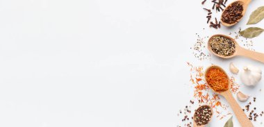 Çeşitli baharatlar kaşık ve beyaz arka plan üzerinde otlar