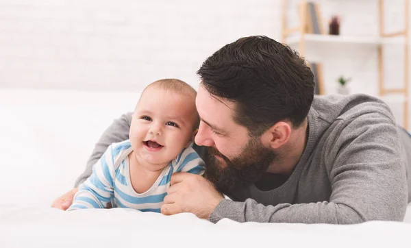 Szczęśliwy ojciec bawi się noworodek w sypialni — Zdjęcie stockowe