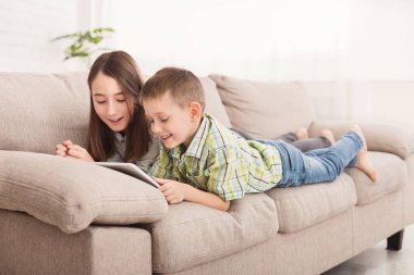 Dalgın kardeşler koltukta yalan kitap okuma