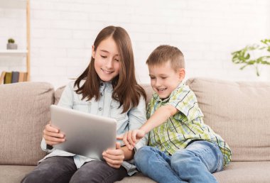 Kız ve erkek kardeş dijital tablet komik film izlerken