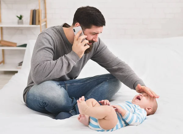 Pai verificando a temperatura e chamando o médico — Fotografia de Stock