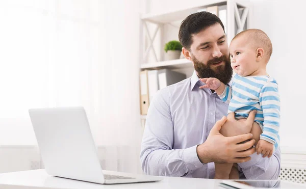 Papá de negocios trabajando en la oficina con el bebé hijo —  Fotos de Stock