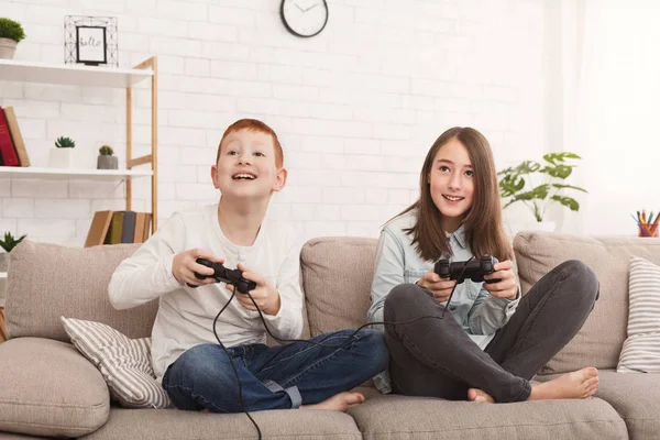 Amistoso hermano y hermana jugando videojuegos juntos — Foto de Stock