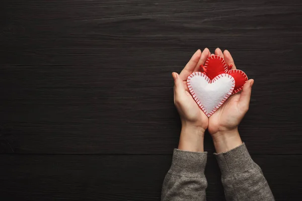 Hintergrund zum Valentinstag, Kissenherzen in weiblichen Händen — Stockfoto