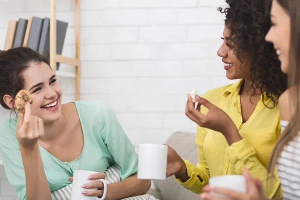 Mejores amigos comiendo galletas y tomando té en casa — Foto de Stock