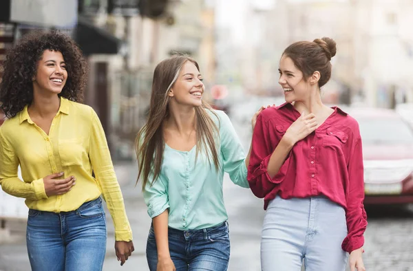 Three happy women walking in the city — Stock Photo, Image