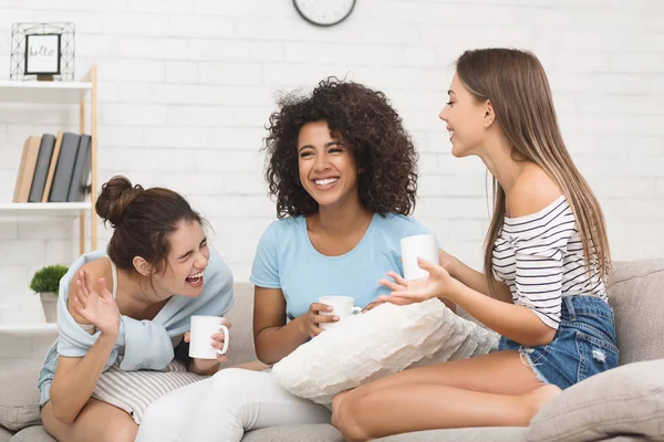 Des amis éclatant de rire, buvant du café à la maison — Photo