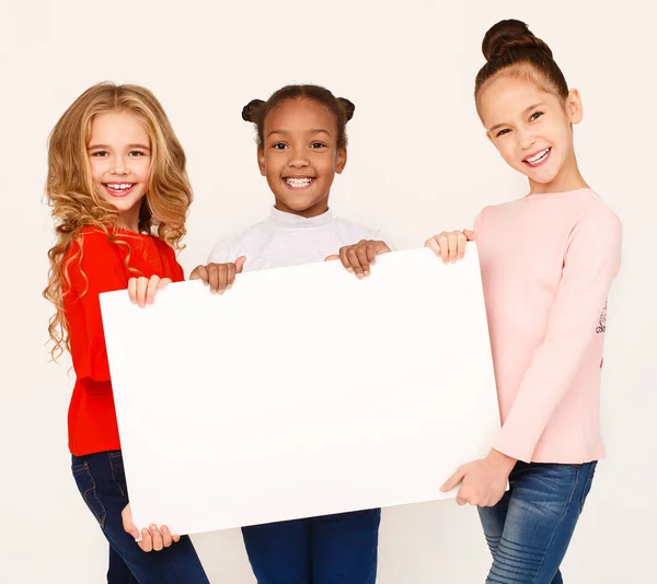 Niñas sosteniendo pancarta de papel en blanco para anuncio — Foto de Stock